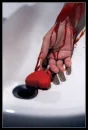 bleeding arm holding a heart