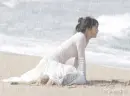 woman crying under the rain on the beach