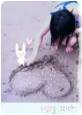 girl drawing a heart in the sand