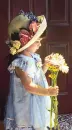 little girl in hat holding flowers