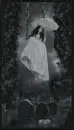 girl on swing with umbrella in cemetery raining
