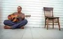 Jack Johnson sitting with guitar