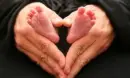 A FATHER HOLDING ITS BABY TOES