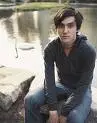 Conor Oberst sitting on a rock