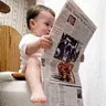 Baby reading newspaper