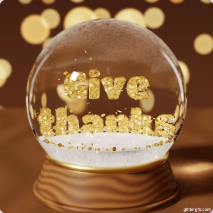 A snow globe on a wooden base with Give thanks in gold glitter letters and gold flakes falling, in a room with warm lights